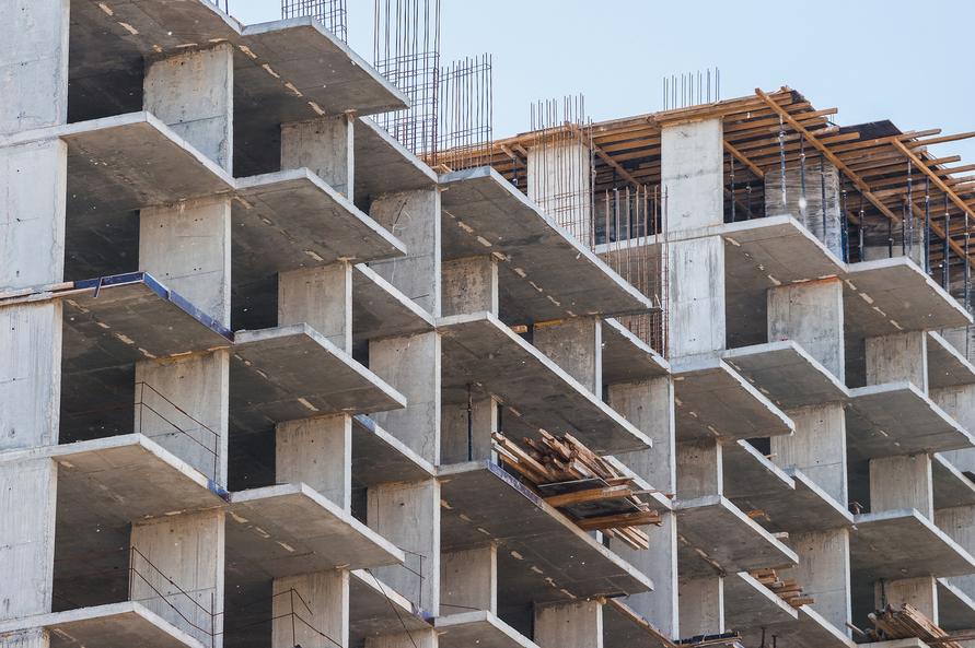 Close-up of a concrete building under construction, showcasing exposed floors and rebar framework.