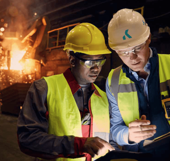 KrampeHarex employees refractory concrete Two KrampeHarex employees look at a screen together in front of a fire